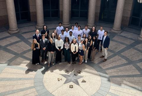 group of interns pose in front of Texas capitol