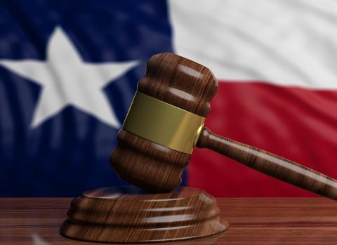 wooden gavel in front of Texas flag