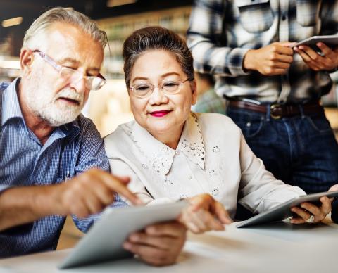 senior couple at table reviewing documents and smiling