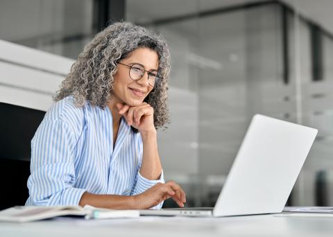 woman attends a webinar on her laptop